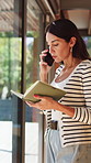 Phone call, notebook and woman in home with communication, planning or advice for schedule. Talking, window and female person with diary for mobile discussion or contact on cellphone in apartment.