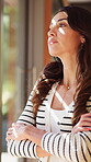 House, window and woman with arms crossed, thinking and homeowner with thoughts on break or daydream. Future, plan and mature person with serious decision, relax and reflection on property investment