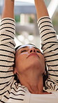Stretching, home and happy woman on couch for break, wellness or chill on peaceful holiday in lounge. Calm, mature person and smile on weekend, relax and comfortable on sofa and resting in house