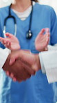 People, doctor and handshake with team applause for partnership, agreement or deal in hospital. Healthcare, employees or colleagues shaking hands with group for medical service or success in clinic