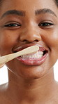 Black woman, face and bamboo with brushing teeth in studio, foam and recycling on white background. African person, sustainability and happy with toothbrush, toothpaste and dental care in Kenya