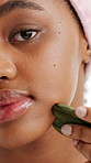 Face, wellness and woman with gua sha for skincare, closeup and dermatology for anti aging benefits. Portrait, facial massage and black person with tool for healthy skin, self care and grooming