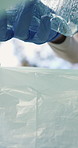 Trash bag, plastic and hands of volunteer for recycling, sustainability or community service. Gloves, cleaning and charity worker to collect garbage, outreach program and ngo project to remove litter