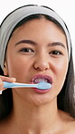 Dental, face and woman brushing teeth in studio for oral hygiene, getting ready and fresh breath. Routine, person and toothbrush on white background for mouth cleaning, plaque removal and self care