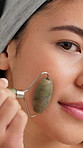 Skincare, jade roller and face of woman in studio for lymphatic drainage, self care or detox. Facial tools, holistic treatment and natural beauty with female person for circulation and massage
