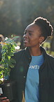 Volunteer, woman and walk in park with plants, sustainability and smile for eco friendly NGO project. Conservation, charity and black person outdoor with tree for gardening, ecology and outreach.