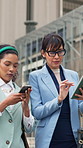 Walking, phone and business women with tablet in city, schedule review and planning investment pitch. Discussion, people and finance team with idea for venture presentation, tech and brainstorming
