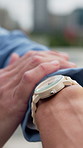Hands, watch and travel in city with waiting for transport, driver and late with schedule in street. Person, clock and check time for commute with delay for ride, taxi or bus on business trip in town
