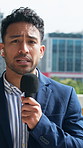 Face, anchor and man with mic in city, explaining story and live report for breaking news coverage. Portrait, talking and reporter with tech for broadcast, current events update and pov in town