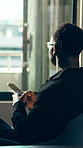 Back, man and thinking with phone in office for communication, contact client and email response. Business person, tech and texting for feedback reflection, schedule update and proposal networking