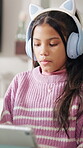 Headphones, reading and girl with tablet in home, streaming movie and subscription site to watch show. Serious, film series and child with tech for multimedia app, weekend entertainment or connection