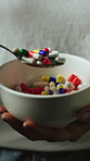 Hands, person and bowl with pills in studio for addiction, substance abuse and mental health. Woman, eating and medication for breakfast, illegal tablets and prescription craving on dark background