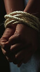 Kidnapped, hands and prisoner with rope in studio, abduction crisis and capture hostage for bondage. Human trafficking crime, victim and person with fear for danger, vulnerability and dark background