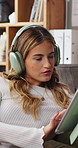Typing, tablet and woman with headphones on sofa for online videos, social media and streaming. Relax, apartment and person on digital tech for internet, website and connection for watching podcast