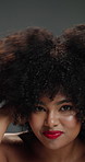 Face, woman and happy with haircare in studio with curly texture, natural growth and maintenance. Female person, afro hairstyle and treatment for hydration glow, grooming benefits and gray background