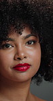 Beauty, face and woman with afro, haircare or cosmetics for healthy natural texture, glow and studio. Hair, growth and person with pride for makeup, gray background and smile with lipstick in Brazil
