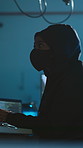 Hacker, laptop and mask in office for software, system or phishing website update for scam. Night, programmer and criminal with ransomware for database theft, cybercrime or malware attack with hoodie