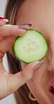 Beauty, skincare and cucumber with eye of woman in studio for cosmetics, hydration and facial. Self care, glow and organic treatment with female person on white background for clean, natural or spa
