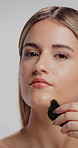 Skincare, gua sha and face of woman in studio for lymphatic drainage, self care or detox. Facial tools, holistic treatment and natural beauty with female person on white background for circulation