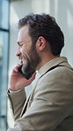Businessman, conversation and window with phone call in office for corporate discussion or proposal. Man, employee or talking with smile on smartphone for business negotiation or advice in workplace