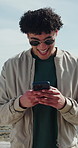 Ocean, funny and man with phone, internet for online chatting and app for entertainment. Outdoor, happiness and person with tech for social media, laugh and connection for communication in Miami