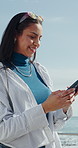 Seaside, smile and woman with phone, internet for online chatting pr app for tourism destination. Beach, typing or person with tech for social media, location or connection for communication in Miami
