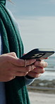 Beach, hands and woman with phone, internet for online chatting and message to contact. Seaside, typing and person with tech for social media, browse for location and download for tourism info