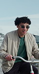 Happy man, cycling and beach with bicycle on promenade for outdoor ride, tourism or fun journey. Male person, cyclist or tourist with smile on bike for travel, sightseeing or adventure by ocean coast