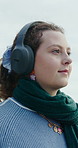 Woman, walking and relax with headphones, outdoor and listening to music on winter break and online. Calm, person and streaming audio with tech on holiday adventure, smile or entertainment on weekend