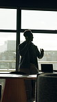 Black man, conversation and window with phone call in office for real estate negotiation or advice. Businessman, realtor or building investor talking on smartphone for property investment or proposal