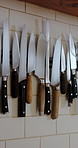 Kitchen, restaurant and wall with knives on rack for cooking equipment, utensils and storage. Hospitality, catering and magnetic holder with cutlery, blade and professional tools for culinary career