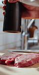 Kitchen, meat and hands of chef with pepper for cuisine, dinner and gourmet recipe for flavor. Cooking, food and person with steak, beef and seasoning for meal prep, nutrition and culinary skills