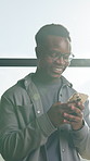 Cellphone, typing and black man in office with texting, networking or communication on mobile app. Technology, lens flare and African male person with phone for online email with contact in workplace