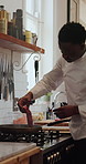 Kitchen, cooking and chef with steak by stove at restaurant for meal prep, cuisine and recipe. Hospitality, catering and black man with meat in pan for dinner, lunch and food for culinary skills