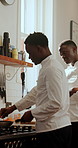 Black man, chef and conversation in kitchen for planning, advice or listen for restaurant training. People, mentor and team discussion with learning, culinary arts and cuisine with cooking and frying