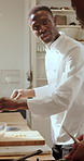 Black man, chef and conversation in kitchen for collaboration, advice or training for restaurant. People, mentor and team discussion with learning, culinary arts and cuisine with cooking and frying