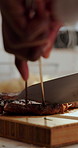Hands, knife and steak with person in kitchen for culinary dish, prepare and gourmet meal. Cuisine, protein and slice with chef cutting beef or meat for cooking, diet and nutrition in restaurant