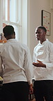 Black man, chef and conversation in kitchen for demo, advice or listen for restaurant training. People, mentor and team discussion with learning, culinary arts and cuisine with cooking and frying