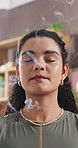 Home, smoke and woman with incense stick for meditation, mindfulness or spiritual awareness on break. Zen, person and stress relief with aromatherapy, breathing and healing with fragrance in house