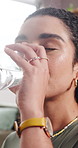Woman, pills and drinking water in home for healthcare supplements, vitamins or minerals in lounge. Person, glass and box for pharmaceutical product, drugs and wellness with dosage schedule at house
