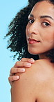 Face, glow and woman in studio, skincare and dermatology on blue background. Cosmetics, aesthetic and person with wellness, beauty and treatment for healthy skin, grooming and textures with shine