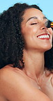 Brush, makeup and woman in studio with beauty, foundation or highlighter for facial glow. Happy, blush and person with cosmetic tool for face cosmetology routine for confidence by blue background.