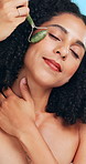 Woman, jade roller and skincare in studio for circulation, anti aging or facial healing for beauty. Aesthetic, person and stone tool for lymphatic drainage, dermatology or cosmetic on blue background