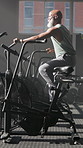 Fitness, black man and exercise bike in gym for cardio, workout and challenge for health. Athlete, mature person and elliptical machine at wellness club for physical training, endurance or cycling