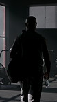 Fitness, man and walking in gym with bag for spin class arrival, getting ready or drinking water. Back, mature black person and hydration at window for cycling preparation, bike exercise and sunshine