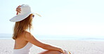 Vacation, girl and relax with hat on beach for summer getaway, sunbathing and exploring nature. Back, peaceful woman and sunhat at seaside for tropical holiday, sightseeing ocean or trip destination