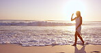 Woman, sunset and running from waves for travel, fun and vacation wellness outdoor. Sky, space and female person on ocean shore for happiness, fresh air and break on getaway trip for self care