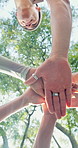Below, teamwork and stack hands at park for support, solidarity and connection for goal. Pile, low angle and group of people together in nature for synergy, trust and motivation for mission outdoor