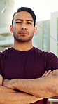 Man, arms crossed and face in city for fitness, confidence and break summer sunshine. Person, outdoor and runner in urban town, serious and rest for exercise, wellness and portrait in Indonesia