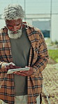 Black man, farmer and tablet in greenhouse with typing, agriculture and inspection for sustainable food production. Mature person, tech and application with report, checklist or notes for farming